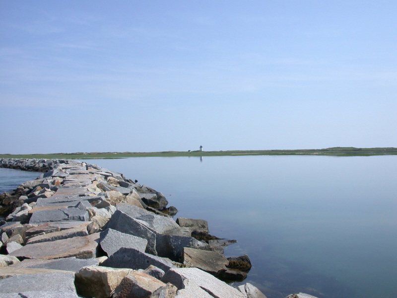 Breakwater in Provincetown, Cape Cod with a lighthouse in the background.
